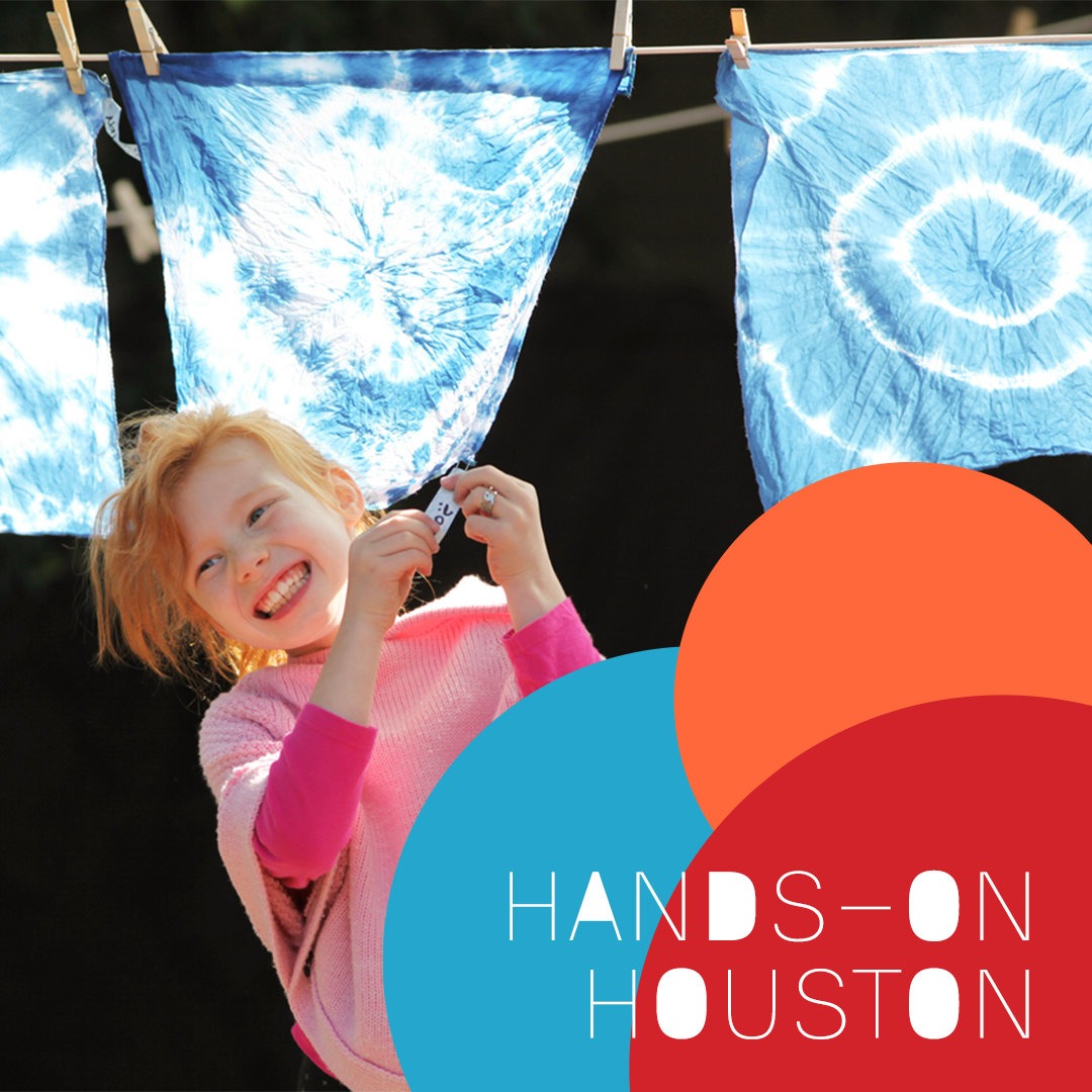 Image of previous Hands-on Houston Indigo dyed handkerchiefs hanging on a clothes line to dry with a young girl smiling in front.
